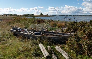 Foto af gammel fiskebåd ved bredden
